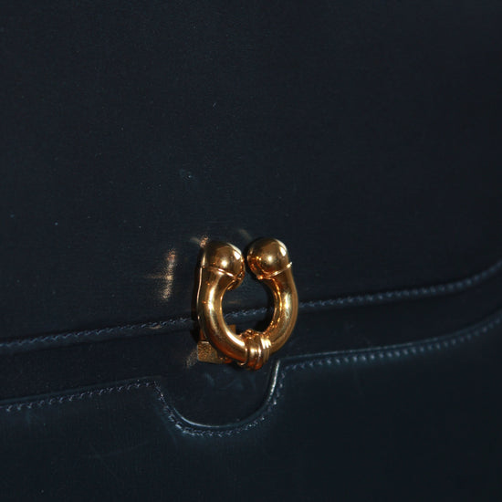 closeup of clasp on vintage navy gucci calfskin handbag with gold hardware